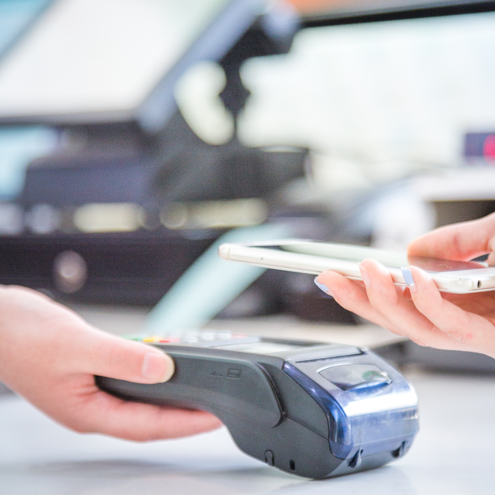 a person using their mobile as payment over a payment terminal